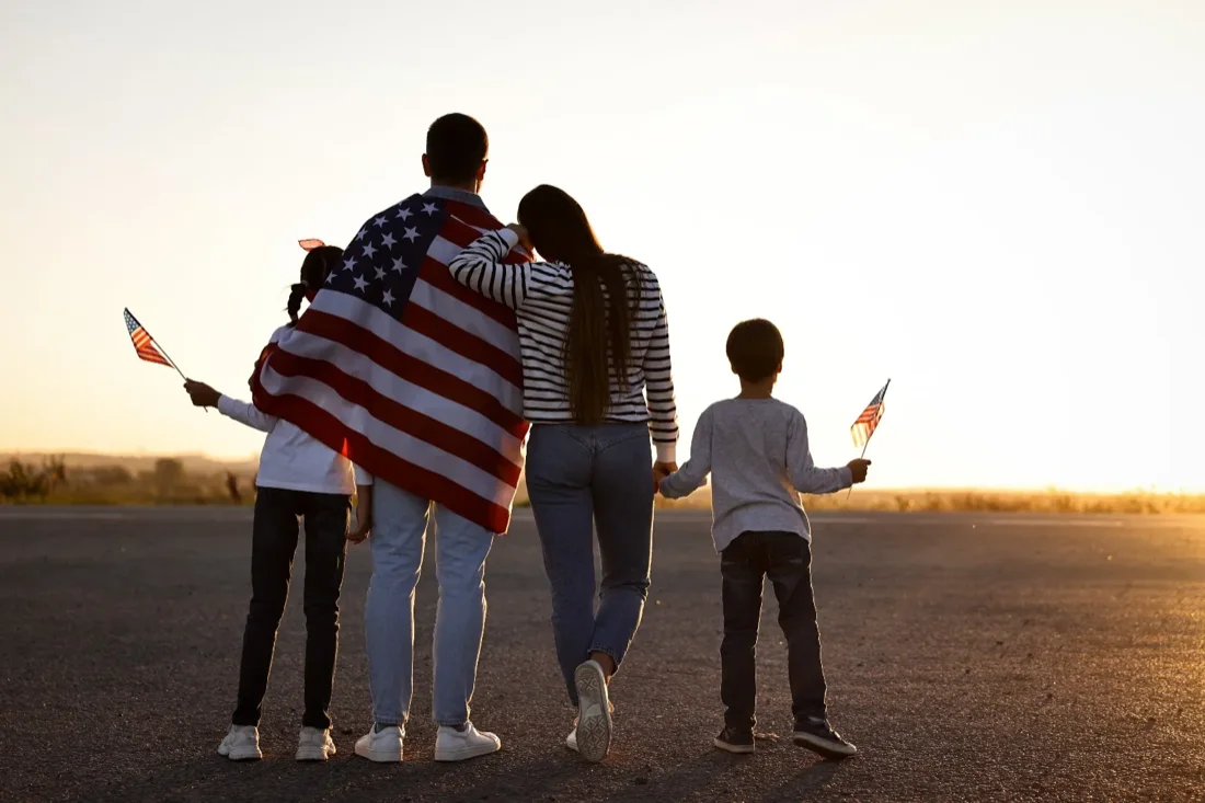 An American family walking together, wrapped in the stars and stripes, after relocating to the Netherlands